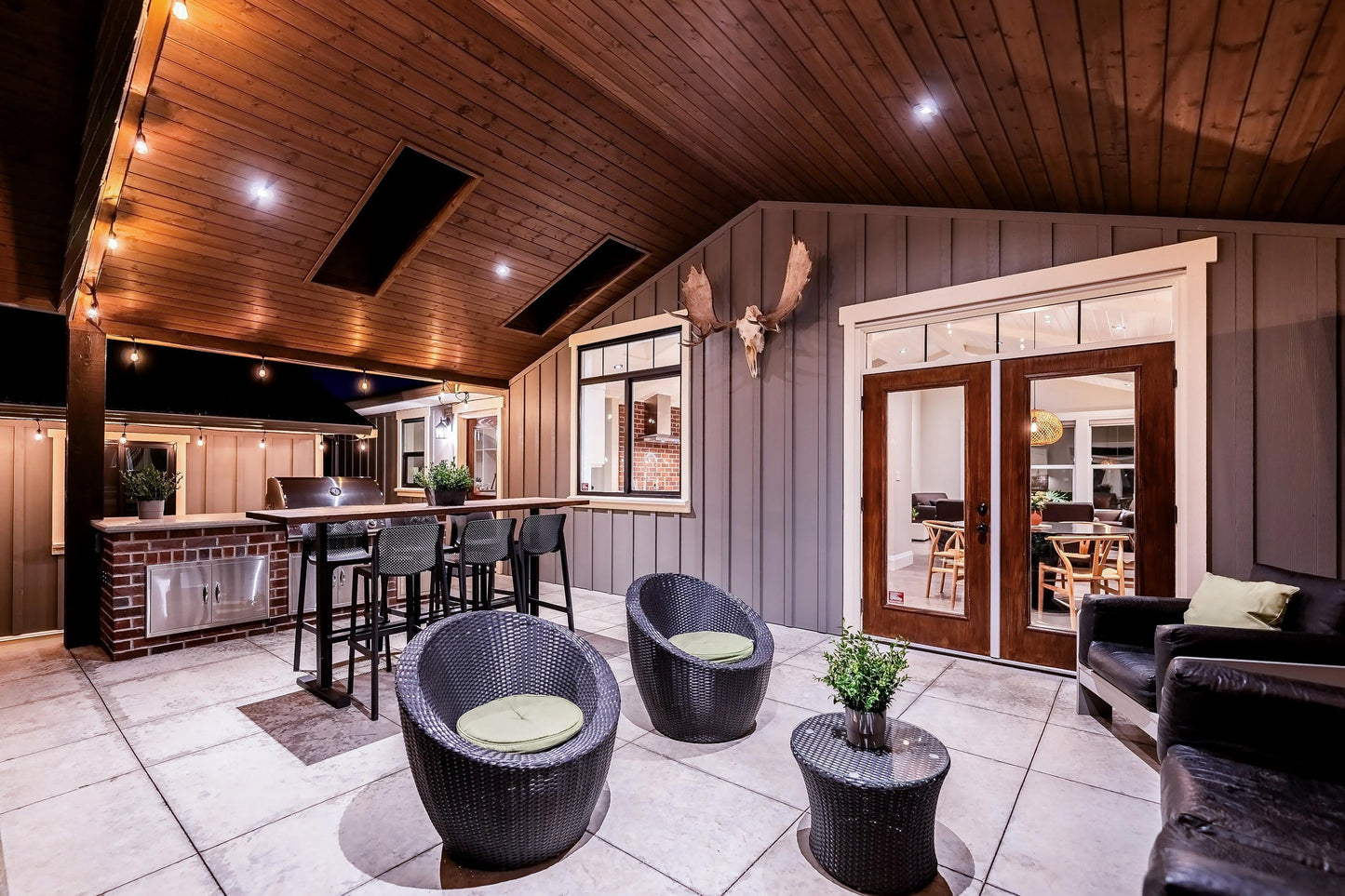Wide angle view of the back patio, including; seating, table and BBQ. 