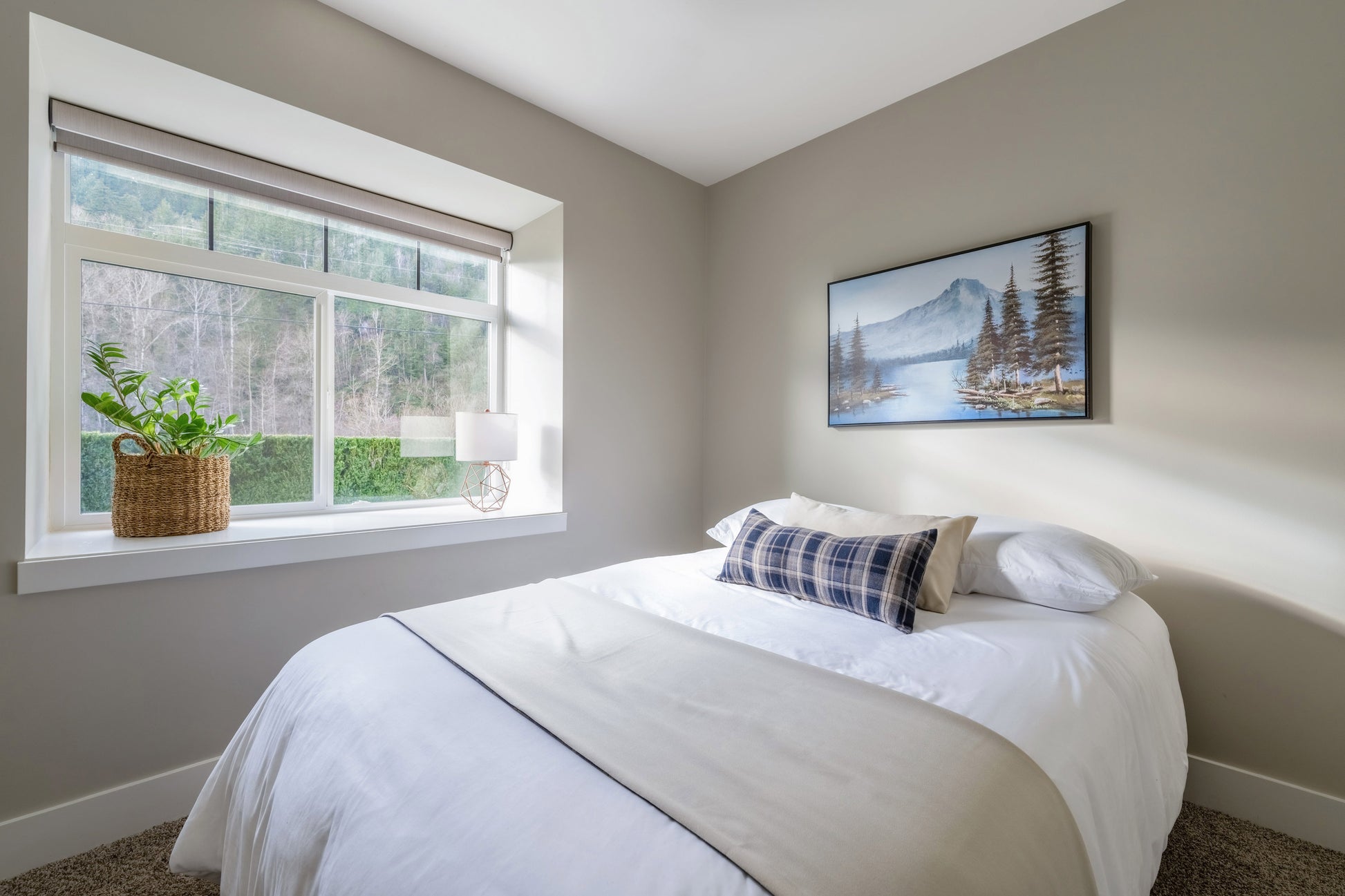 Wide angle view of double bed with window. 